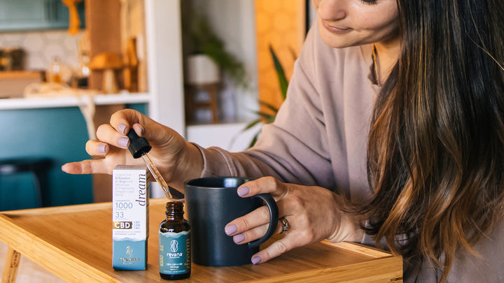 Women adding CBD tincture to tea or coffee.