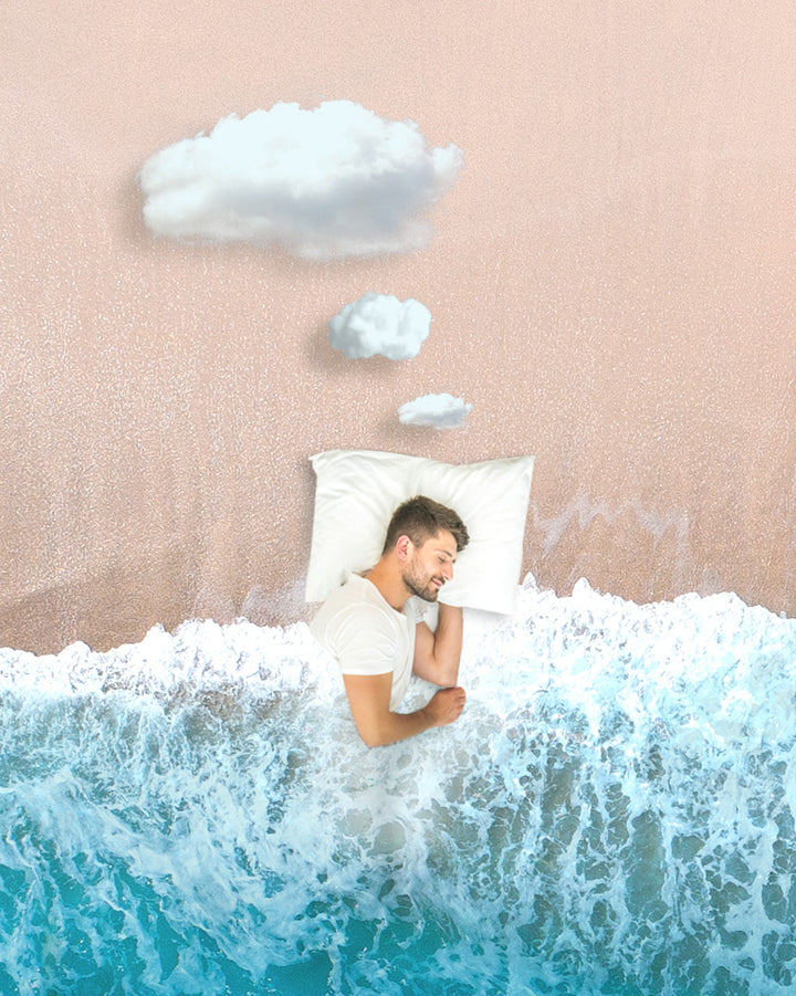 man in white shirt laying on a pillow and using the ocean as a blanket